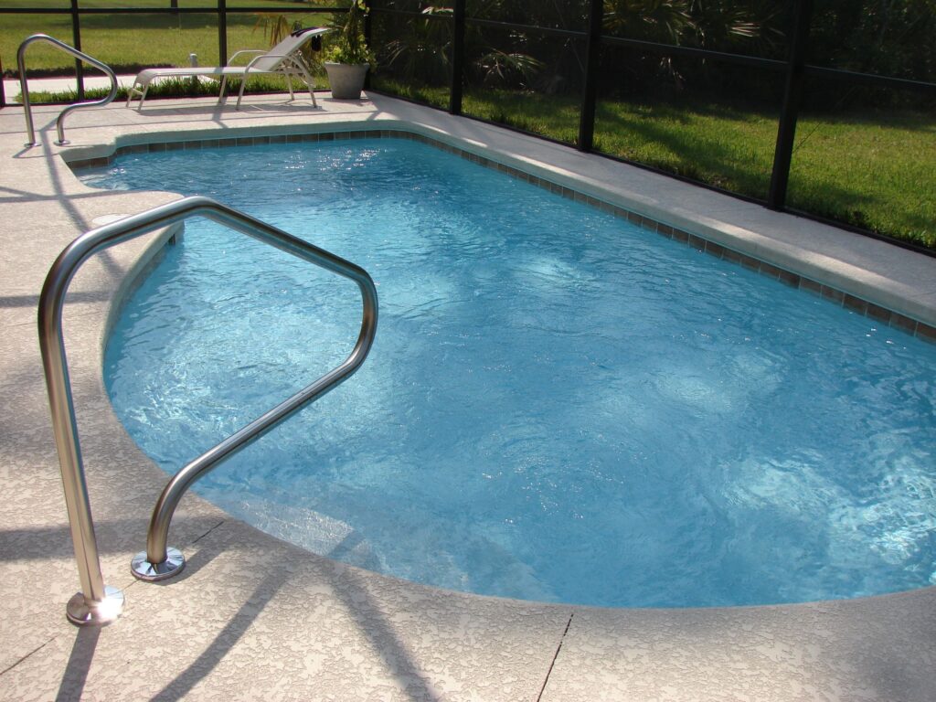 Small modern plunge pool surrounded by greenery and stone walls.